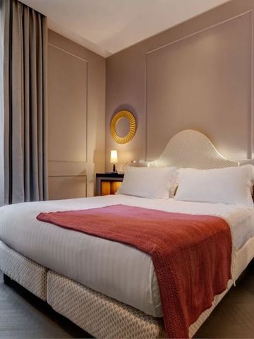 Komfortables Doppelzimmer mit dekorativem Spiegel und rotem Akzent