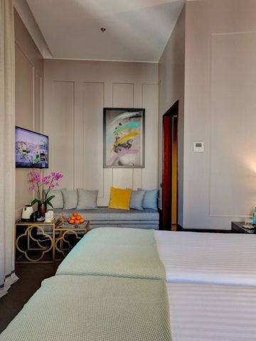 Helles Hotelzimmer mit Sitzbereich und modernen Kunstwerken