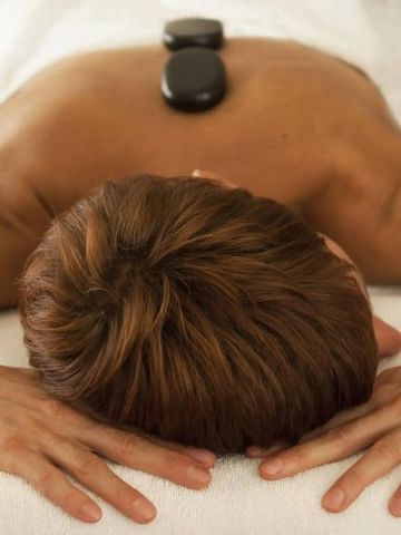 Entspannende Hot-Stone-Massage auf weichem Massagetisch im Spa-Bereich