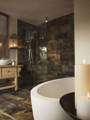 Elegantes Badezimmer mit freistehender Badewanne und rustikalem Waschbecken