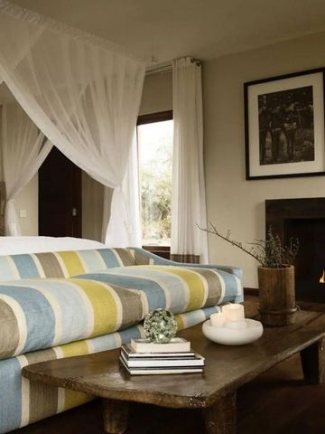 Gemütliches Schlafzimmer mit Kamin und bunter Couch im Hotel