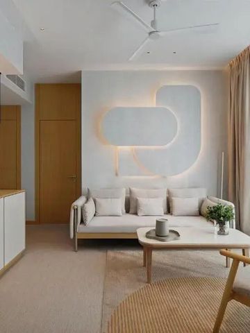 Helles Wohnzimmer mit stilvoller Möblierung und Akzentbeleuchtung