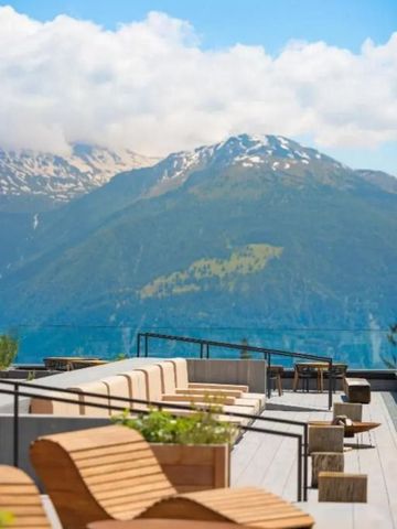 Panoramablick auf schneebedeckte Berge von moderner Rooftop-Terrasse.