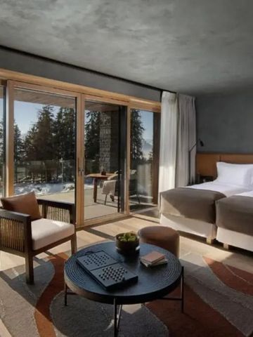 Modernes Zimmer mit breiter Fensterfront und Blick auf verschneite Landschaft.