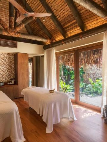 Entspannender Spa-Raum mit zwei Massageliegen und Gartenblick