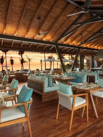 Restaurant mit Holzdekor und atemberaubendem Meerblick bei Sonnenuntergang