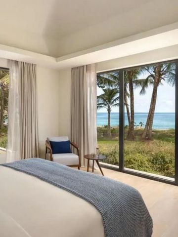 Helles Schlafzimmer mit großen Fenstern und Meerblick.