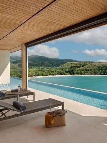 Private Terrasse mit Liegen und Blick auf den Infinity Pool und Hügel