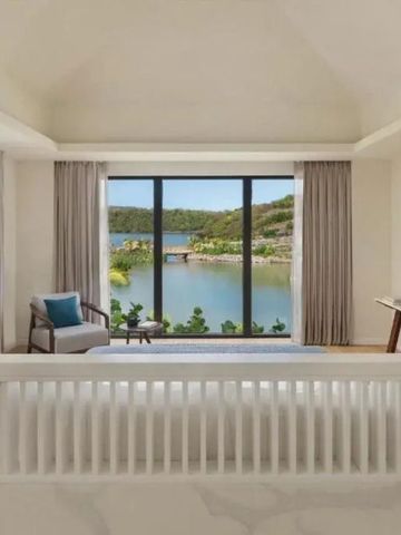 Zimmer mit großer Fensterfront und Aussicht auf Wasser