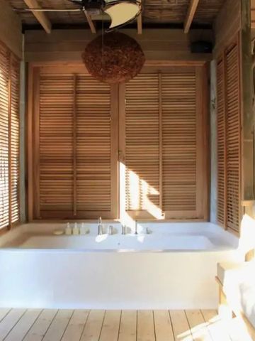 Hölzernes Badezimmer mit großer Badewanne und Tageslicht