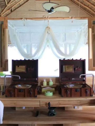 Luxuriöses Badezimmer mit stilvollen Waschbecken und tropischem Flair