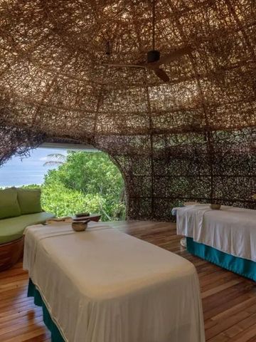 Spa-Raum mit Behandlungsbetten und Panoramablick auf die Natur