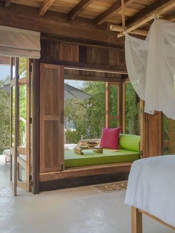 Offenes Schlafzimmer mit grüner Lounge und natürlicher Holzeinrichtung.