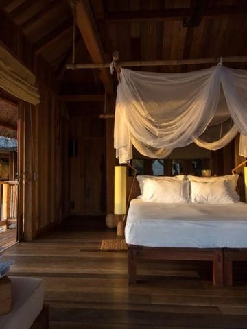 Gemütliches Schlafzimmer mit Himmelbett und gedämpfter Beleuchtung.