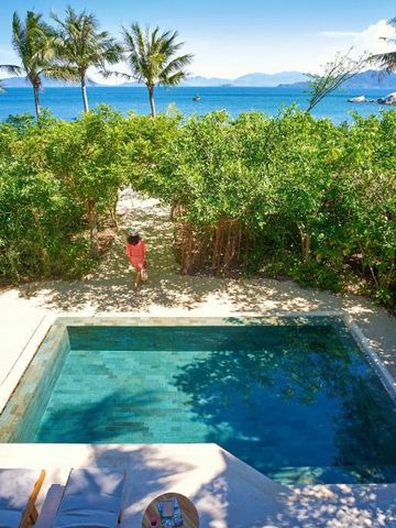 Privater Pool mit Blick auf das Meer und Palmen im Hintergrund