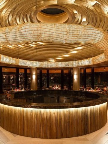 Elegantes Restaurant mit moderner Holzausstattung und großem Kronleuchter