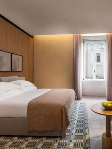 Helles Hotelzimmer mit großem Fenster, stilvollem Bett und moderner Einrichtung