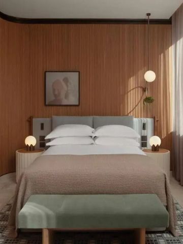 Schickes Hotelzimmer mit getäfelten Wänden, weichem Bett und stilvollem Lichtdesign