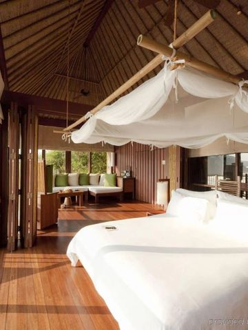 Helles Schlafzimmer mit Holzdecke und Panoramablick in tropischem Design