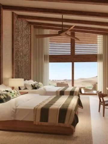 Zweibettzimmer mit stilvollen Holzelementen und großer Fensterfront mit Wüstenpanorama