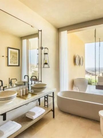 Luxuriöses Badezimmer mit freistehender Badewanne und Panoramablick.