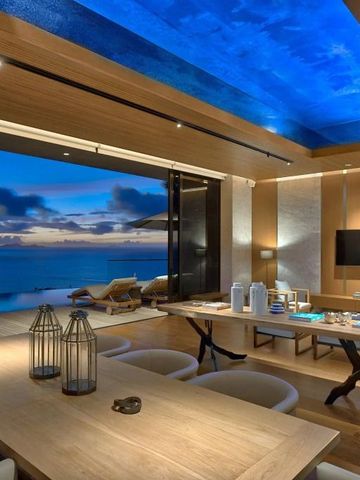 Luxuriöse Villa mit Essbereich und Blick auf das Meer bei Sonnenuntergang