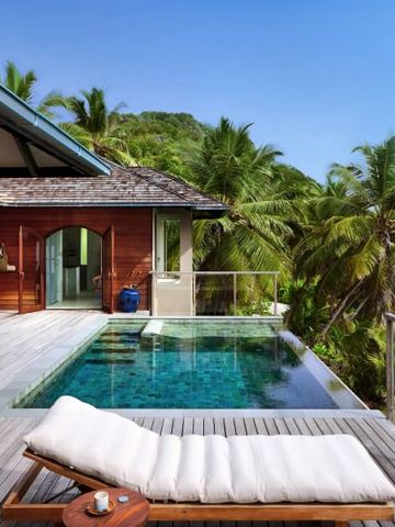 Private Poolvilla mit Liegestuhl und Sicht auf Palmen und Meer