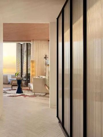 Elegante Suite mit Blick auf den Sonnenuntergang durch große Fenster.