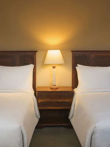 Gemütliches Hotelzimmer mit zwei Einzelbetten und warmer Beleuchtung