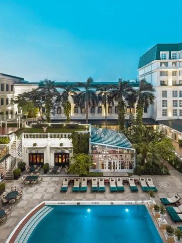 Weitläufige Poollandschaft mit Palmen und umgebenden historischen Gebäuden