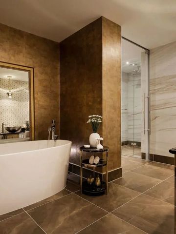 Luxuriöses Badezimmer mit eleganten Fliesen und freistehender Badewanne.