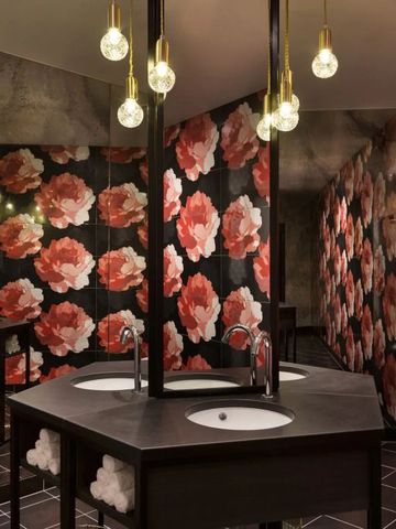 Luxuriöses Badezimmer mit schwarz-roten Blumenmustern und modernen Waschbecken