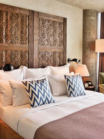 Elegant eingerichtetes Gästezimmer mit dekorativen Holzelementen und Kissen