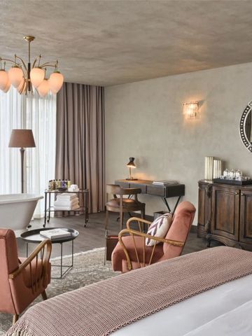 Geräumiges Hotelzimmer mit Badewanne, luxuriöser Dekoration und Schreibtisch