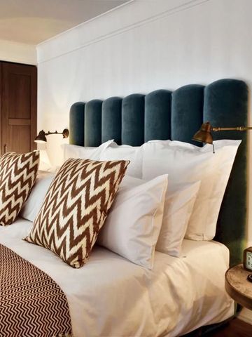 Elegantes Schlafzimmer mit gepolstertem Kopfteil und weichen Kissen