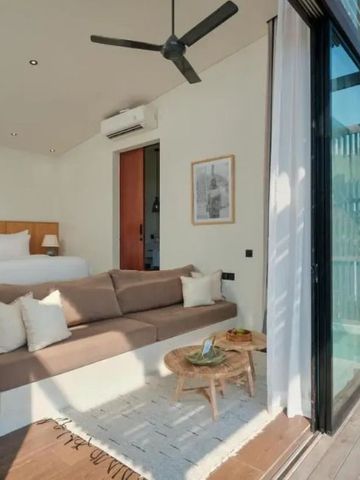 Zimmer mit großer Fensterfront, Sofa, Doppelbett und direktem Zugang zur Terrasse.