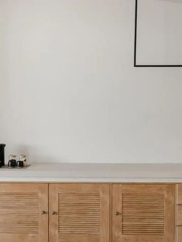 Schlichtes Sideboard mit Kaffeemaschine und minimalistischer Dekoration.