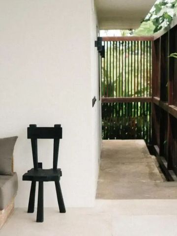 Moderner Sitzbereich mit Sofa und Blick auf üppiges Grün. Schlichtes Design.