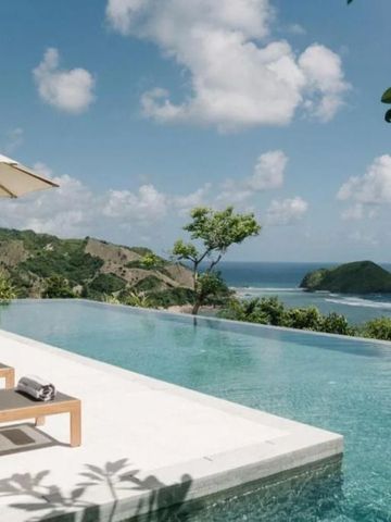 Infinity Pool mit Meerblick und grünen Hügeln im Hintergrund