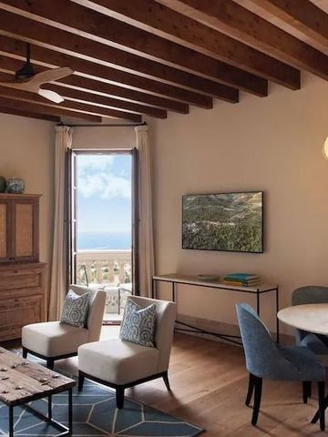 Elegantes Wohnzimmer mit Holzbalkendecke und Meerblick.