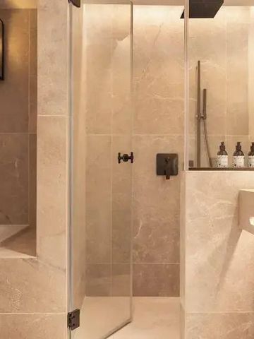 Luxuriöse Badezimmerdusche mit Marmorverkleidung und modernen Armaturen.