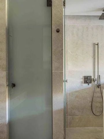 Moderne Dusche aus Glas und Stein in einem eleganten Badezimmer.
