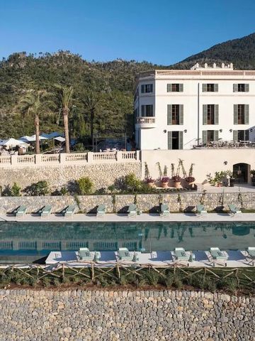 Hotelgebäude mit großem Pool und Palmen im Vordergrund