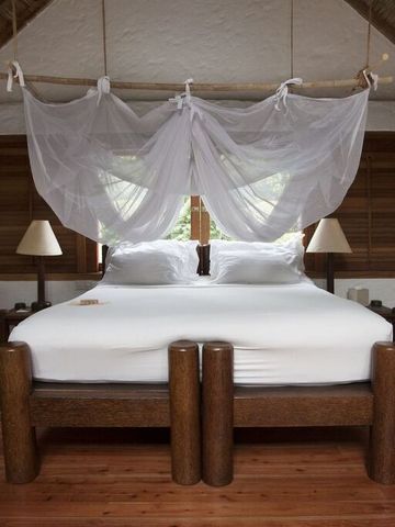 Charmantes Schlafzimmer in einer Lodge mit Himmelbett und rustikalen Holzmöbeln