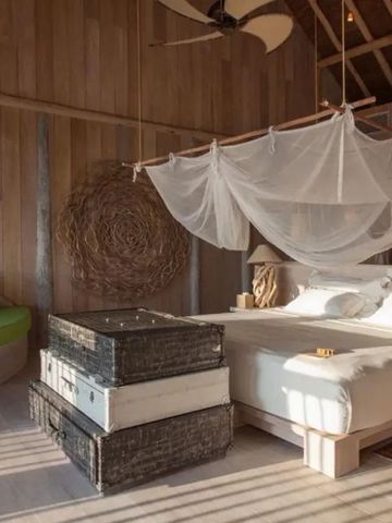 Sonnendurchflutetes Schlafzimmer mit Himmelbett und modernem Dekor aus Naturmaterialien