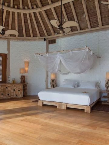 Großzügiger Raum mit rundem Dach, Himmelbett und stilvollen Holzmöbeln