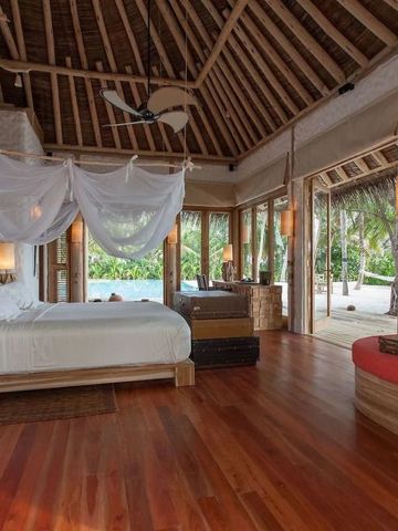 Luxuriöses Schlafzimmer einer tropischen Villa mit Himmelbett und Terrasse.