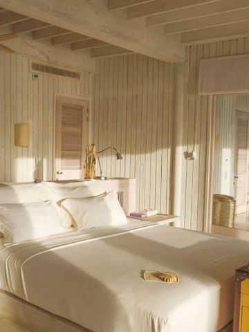 Helles Schlafzimmer mit Holzdekor und Kingsize-Bett in luxuriöser Villa