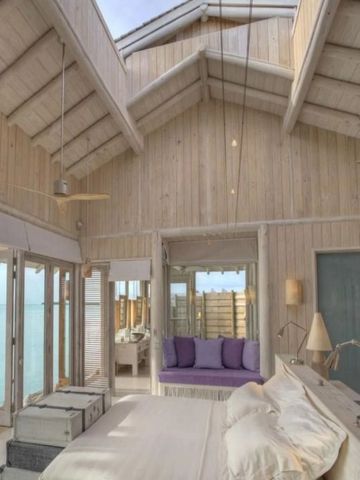 Geräumiges Schlafzimmer mit Holzdekor und Meerblick im Soneva Jani Hotel