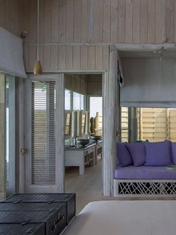 Innenraum eines luxuriösen Zimmers mit gemütlicher Sitzecke im Soneva Jani Hotel
